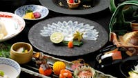 "Fuku Kaiseki Hatsune" includes eight dishes: Fugu Sashimi, Grilled Fugu, Chiri Nabe, Fried Fugu, and Zosui.の画像
