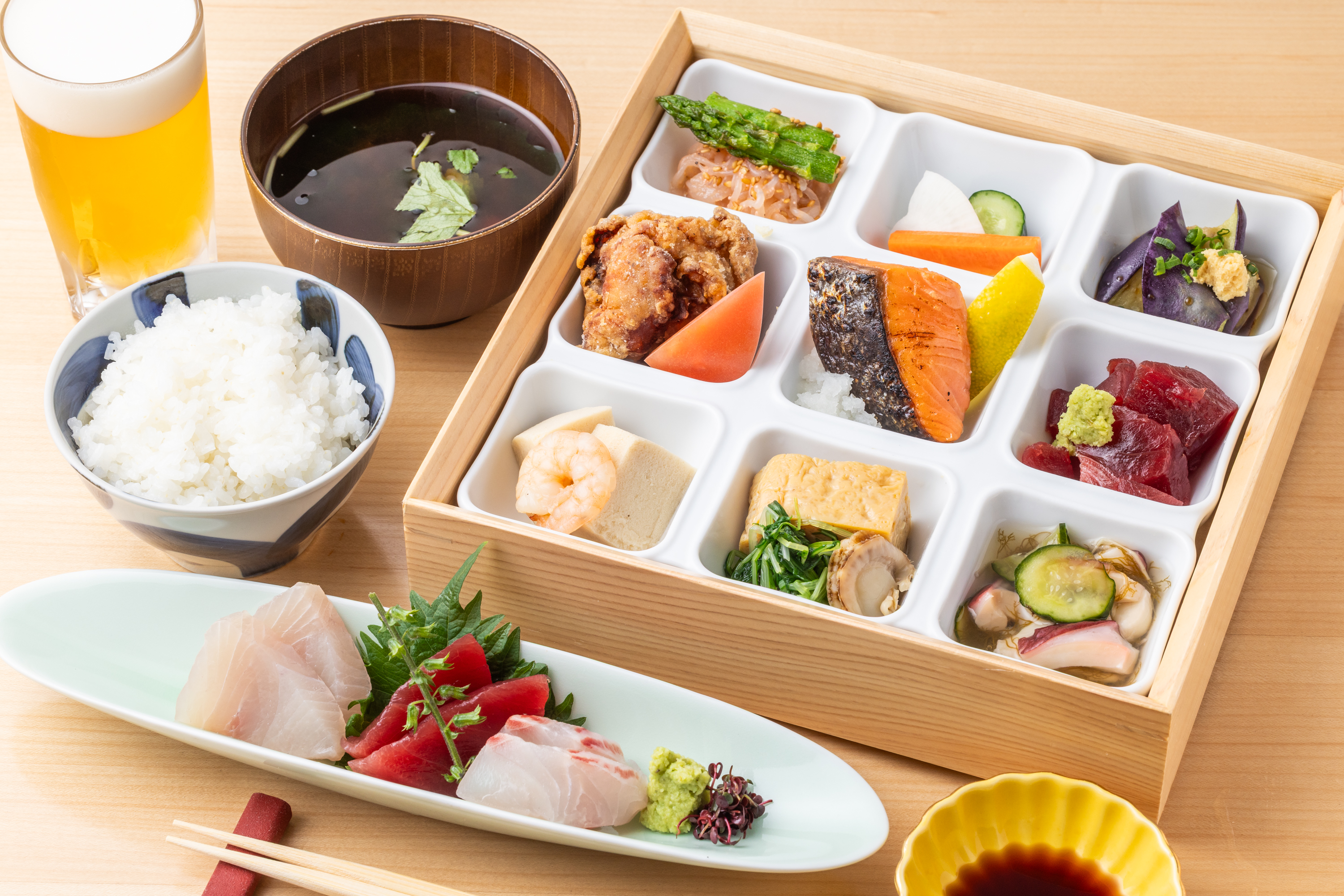 【Lunch】A value lunch set with a layered bento box featuring nine kinds of side dishes, fresh fish sashimi, and one drink.